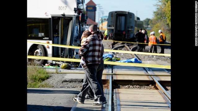 A man carries a child past the scene of the crash on September 18.