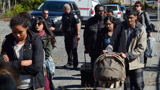 Train passengers are escorted away from the crash site on September 18.