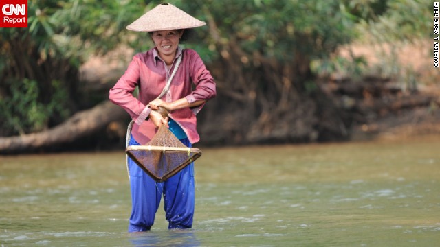 A smiling woman fishes for the day's catch in northern Laos. L. Craig Smith spent four days visiting various villages of the <a href='http://ireport.cnn.com/docs/DOC-941996'>hill tribe people</a>, who "received us with open arms," he said.