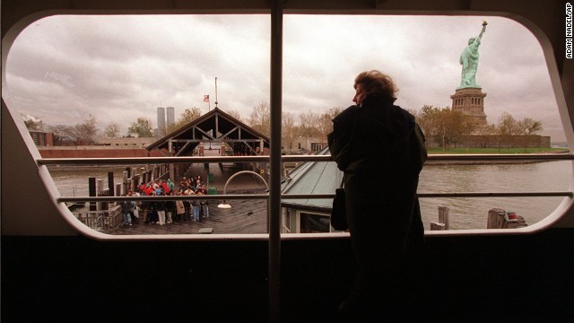 A tourist peers out a ferry window at the Statue of Liberty on November 14, 1995, as a small group of visitors wait on the dock to board the vessel. No passengers were allowed off the boat as both the Statue of Liberty and Ellis Island were closed after federal workers were sent home.