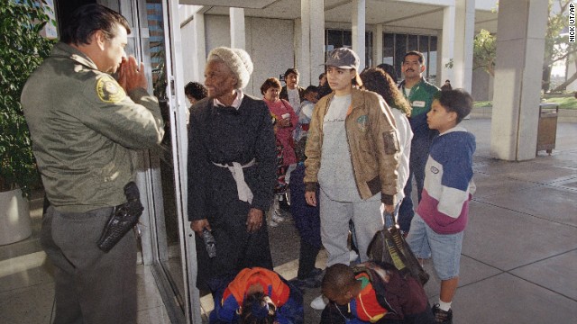 A security guard informs people that the passport office is closed at the Federal Building in Los Angeles on December 18, 1995.
