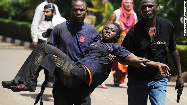 A Kenyan woman is helped to safety after the masked gunmen stormed the upscale mall and sprayed gunfire on shoppers and staff. 