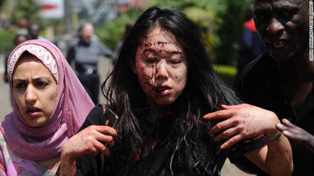 A wounded woman is helped to safety after the attack. The military asked local media not to televise anything live because the gunmen are watching the screens in the mall.