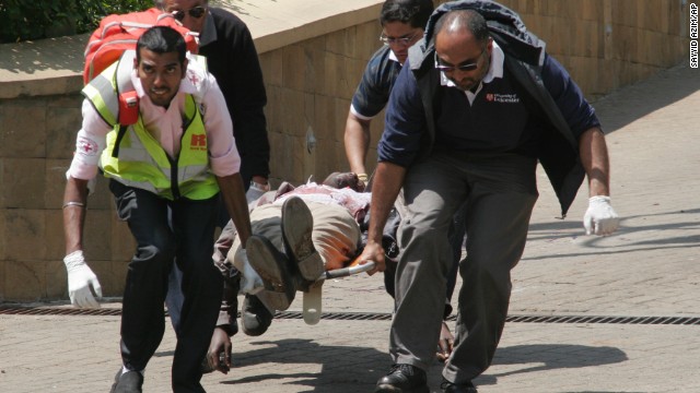 Medical personnel carry a body away. 