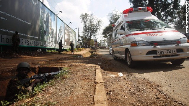 Armed Kenyan forces take position to secure the area around the shopping mall as ambulances move in to carry the injured. 