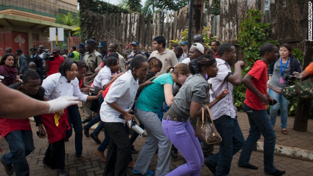 People who had been hiding inside the mall during the gunfire flee the scene. 