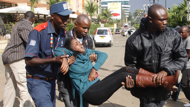 Men help a wounded woman outside the mall on September 21.