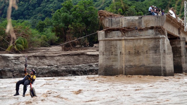 A Red Cross rescuer zip lines across a river at the site of a collapsed bridge near the town of Tierra Colorada, Mexico, on Saturday, September 21. At one point this week, Mexico seemed to be pummeled from all sides by then-Hurricane Manuel and the remnants of Hurricane Ingrid.