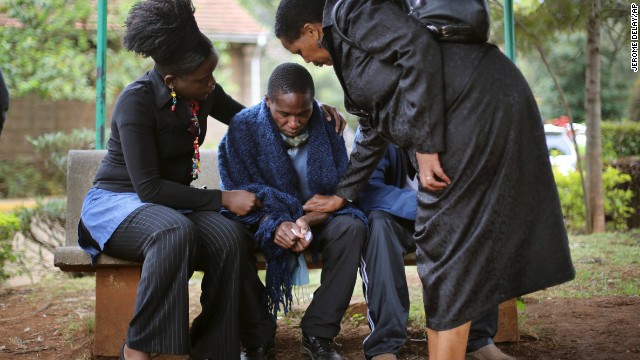 Stephen, center, is comforted by relatives as he waits for the post mortem exam of his father, who was killed in Saturday's attack at the mall. 
