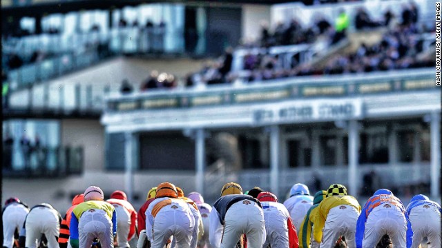 Aintree, Liverpool, UK: Runners making their way past the grandstand at Aintree. Crowhurst prefers jump racing because of its unpredictable nature. A horse that is 10 lengths clear can always fall at the last, he says. 