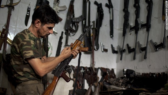 A man checks an AK-47 at his gun shop in Aleppo, Syria, on Saturday, September 21.