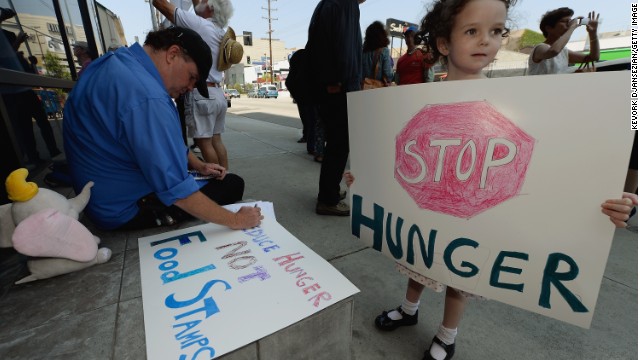 A girl joins her father and others in June in Los Angeles protesting a bill that would cut funding for SNAP, or food stamps. 