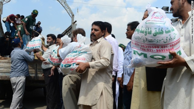 Members of the Pakistani Muttahida Qaumi Movement load relief supplies onto a truck in Karachi on September 25.
