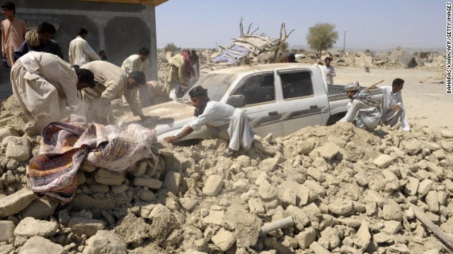People clear debris off of a truck in Awaran on September 25.