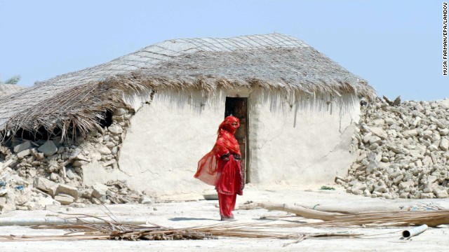 A woman stands in front of the rubble of her destroyed home in Balochistan province on September 25.