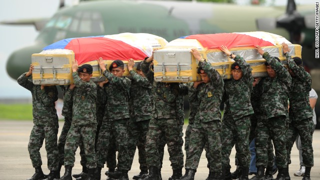Soldiers carry the flag-draped coffin of policemen who died at the Zamboanga rebel attack in Mindanao. The coffins arrive at Villamor airbase in Manila on September 25. Fighting between rebels and soldiers in the city has entered its third week.