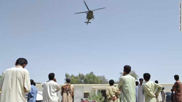 A Pakistani Army helicopter hovers over people as they wait for relief in Awaran on September 26.
