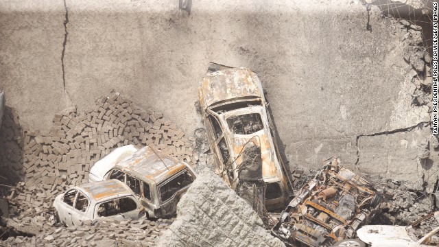Cars sit amid the rubble of the collapsed structure. 