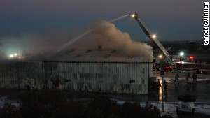 Firefighters pour water on a hangar after a plane crashed into it Sunday night in Santa Monica, California.