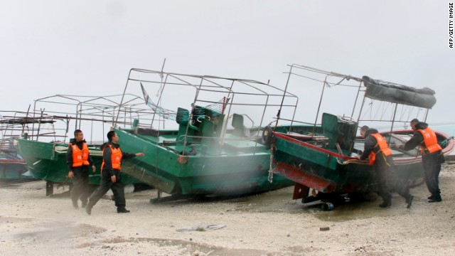Emergency personnel work to secure fishing boats parked in a harbor on Yongxing island, on Sunday, September 29.