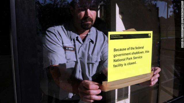 An employee at the Springfield Armory National Historic Site in Springfield, Massachusetts, puts up a sign Tuesday, October 1, to notify visitors that the site is closed because of a government shutdown.