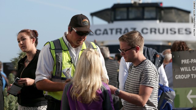 SAN FRANCISCO, CA - OCTOBER 01: Security officer Nick Estrada (2L) helps visitors with information on how to get a refund for tickets purchased for Alcatraz Island on October 1, 2013 in San Francisco, California. Visitors were given refunds for their purchased tickets to Alctraz Island as federal museums and parks across the nation were closed starting today due to a government shutdown for the first time in nearly two decades. (Photo by Justin Sullivan/Getty Images)