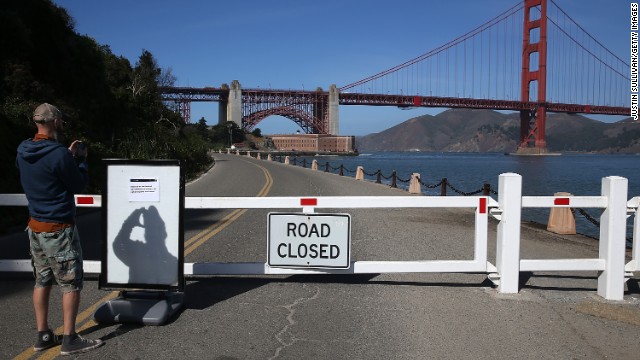 A visitor takes a picture of a sign announcing the closure of the Fort Point National Historic Site due to the partial government shutdown on October 1 in San Francisco, California. 