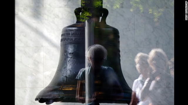 Visitors to Independence National Historical Park are reflected in the window of the closed building housing the Liberty Bell, on October 1 in Philadelphia.