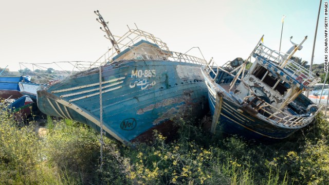 Weather-beaten boats once used by illegal immigrants to arrive on the Italian island of Lampedusa lay in the harbour.