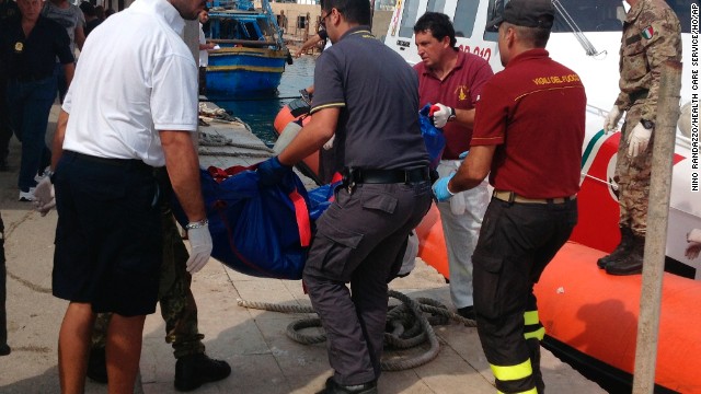 Firefighters unload the body of a drowned migrant from a coast guard boat in the port of Lampedusa on October 3. 