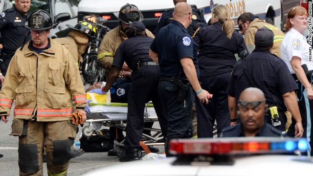 Emergency personnel put an unidentified police officer on a stretcher.