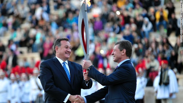 Kapralos (left) hands the flame over to Russia's Deputy Prime Minister Dmitry Kozak ahead of its trip to Moscow, before starting its 65,000-kilometer journey in Sochi on October 7.