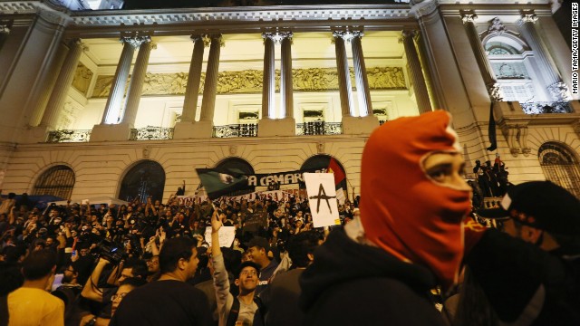 A masked man joins demonstrators in front of a government building during last October's protests in Rio.