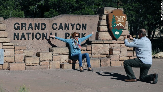 Austrian tourist Ryszard Skrzypek snaps a photo of his wife, Walendowska Malgorzata, close to the entrance to Grand Canyon National Park near Tusayan, Arizona, on Friday, October 4. Park officials have written citations for people trying to sneak into the park.