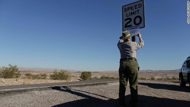 Park maintenance worker Donna Curry tapes up a sign on October 1 notifying visitors the picnic facility in Lake Mead National Recreation Area near Boulder City, Nevada, is closed. A Nevada couple told CNN affiliate <a href='http://www.ktnv.com/news/local/226557661.html' target='_blank'>KTNV-TV</a> they were kicked out of their cabin, which is on federal land.” border=”0″ height=”360″ id=”articleGalleryPhoto005″ style=”margin:0 auto;display:none” width=”640″/><cite style=