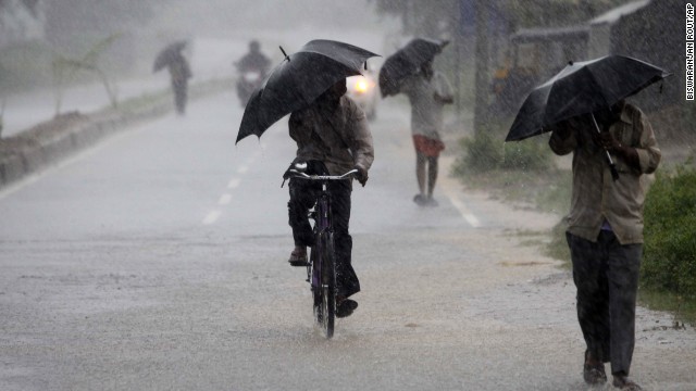 Villagers walking to the cyclone shelter try to block the heavy wind and rain with umbrellas near the town of Chatrapur in India on October 12.