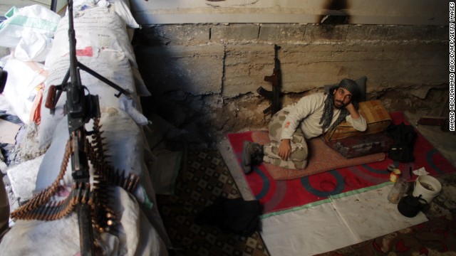 An opposition fighter rests on the front lines in the northeastern Syria city of Deir Ezzor on Tuesday, October 15. 