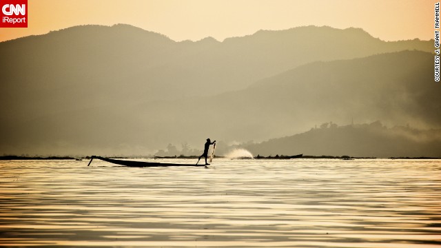 A "leg spinner" paddles across Inle Lake. The unique style of paddling involves using one leg to power the boat while balancing on the canoe's edge with the other. This traditional method frees up the hands for fishing. See more photos of leg spinners in action on <a href='http://ireport.cnn.com/docs/DOC-840861'>CNN iReport</a>.