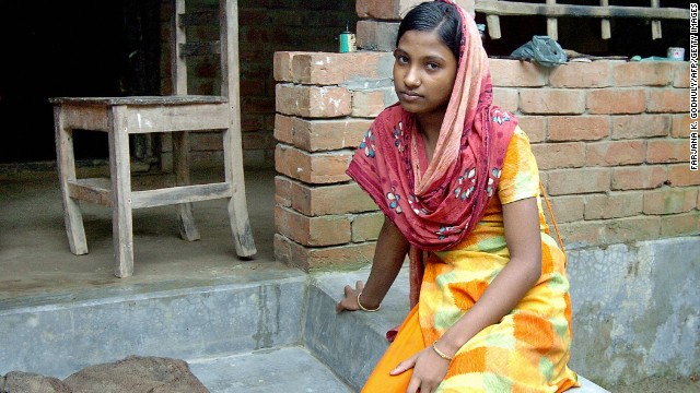 Moyna sits outside her home in the town of Kalora, Bangladesh. As a 14-year-old, she found herself working in an Indian brothel after being tricked into believing she had taken a job in a steel factory.