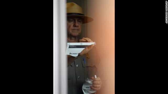 A National Park Service ranger takes down a notice about the government shutdown at the Liberty Bell Pavilion in Philadelphia on October 17.