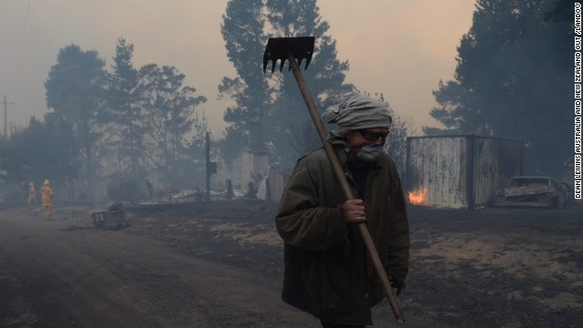Sean Butler walks with his face covered after fighting fires with other residents of the historic township of Newnes Junction on October 17.