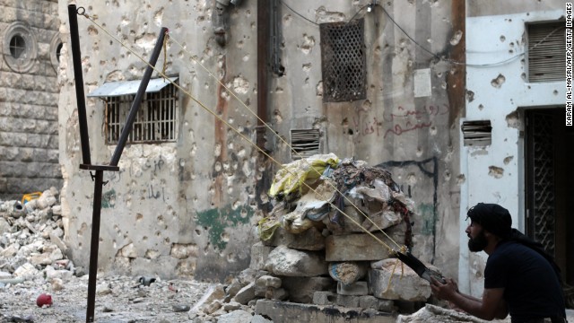 A Syrian opposition fighter aims a catapult toward regime forces in Aleppo, Syria, on Thursday, October 17.