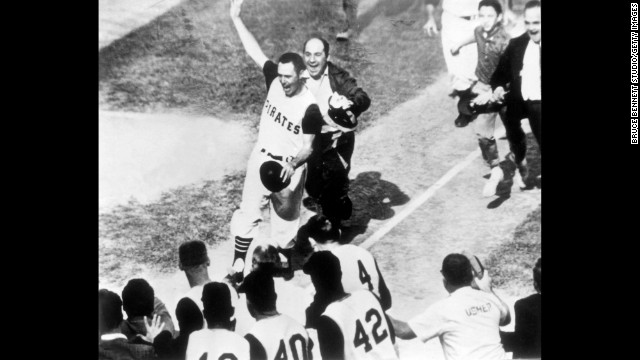 A jubilant Bill Mazeroski of the Pittsburgh Pirates walks across home plate to score the winning run of the World Series against the New York Yankees in 1960. Mazeroski is selling his old gear at an auction in November.