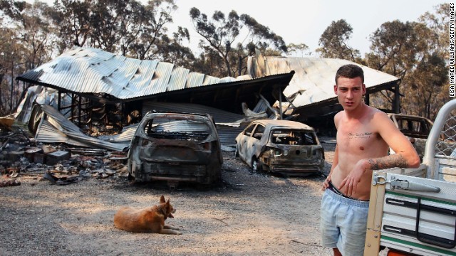 A man in Yellow Rock, Australia, stands in front of a building on Monday, October 21, that was destroyed by the bush fires scorching the country's eastern state of New South Wales.