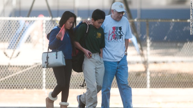 Parents escort a child from Agnes Risley Elementary School after the shooting.