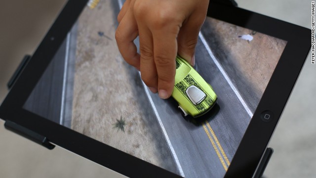 iPads and other tablets have become popular gaming platforms, especially among children. Here a child in London plays with an app from Mattel that allows kids to use Hot Wheels cars and other toys to interact with an iPad.