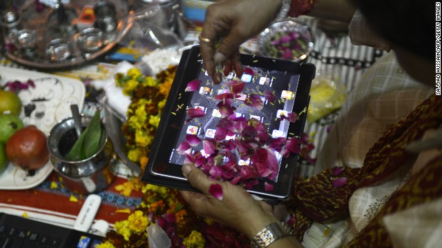 An Indian trader worships an iPad on Diwali, the Festival of Lights, in New Delhi on November 13, 2012. The worshipping of account books has long been an essential part of Diwali for the business community in India, and in a sign of the times some traders are now worshipping electronic gadgets as well. 