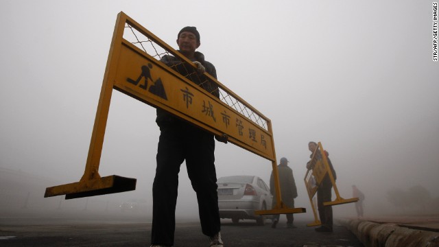 A workman carries a road barrier on a Harbin street on October 21. 