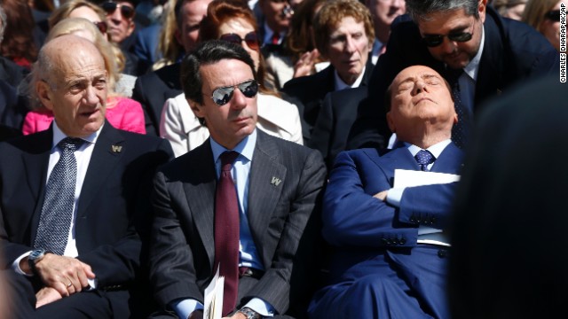 Berlusconi closes his eyes as he listens to a man speak in his ear at the dedication of the George W. Bush Presidential Library in Dallas on April 25.