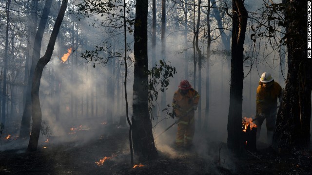 New South Wales Rural Fire Service crews mop up an area after stopping a fire in Bilpin in the Blue Mountains of Australia on October 23.